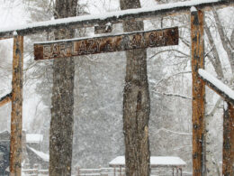 Image of the Bar Lazy J Guest Ranch entrance sign covered in snow