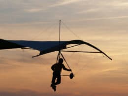 Image of a person hang gliding during sunset