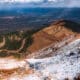 Overlooking snow on Pikes Peak with view of highway switchbacks in distance