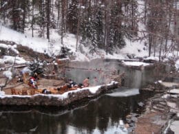 Image of people soaking in the Strawberry Park Hot Springs during winter in Steamboat Springs, Colorado